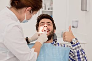 man giving thumbs up during dental appointment beckermeyer dds dentist niles mi